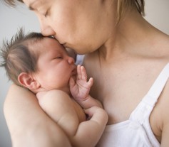 Mother kissing newborn